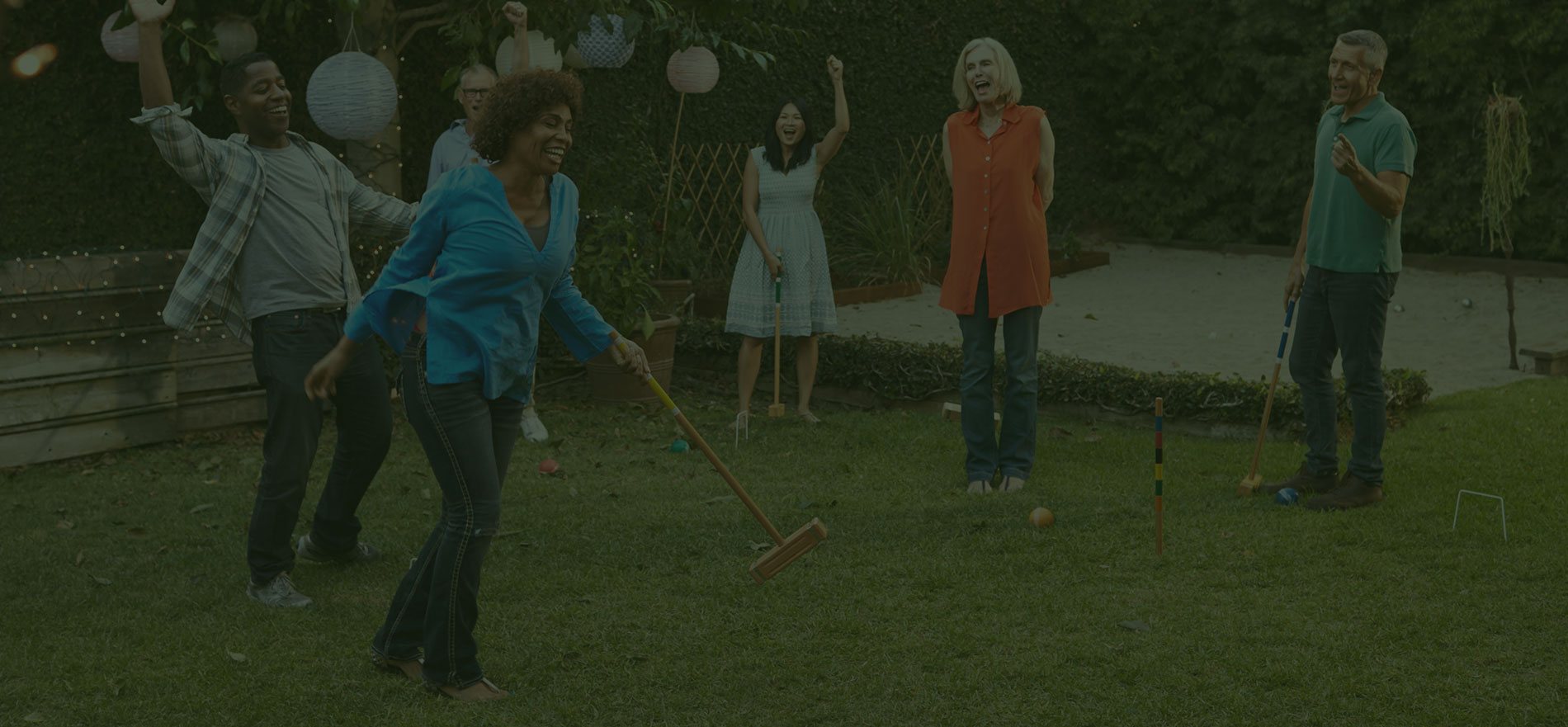 Adults playing croquet together outdoors